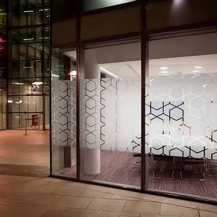 Frosted patterned privacy graphics on glass office windows at night